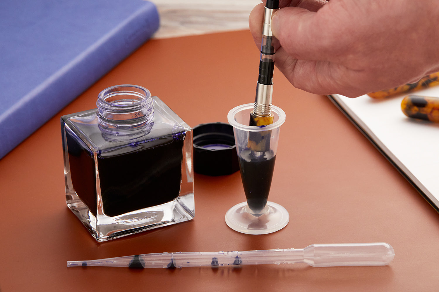 A fountain pen being filled from an Ink Miser vial