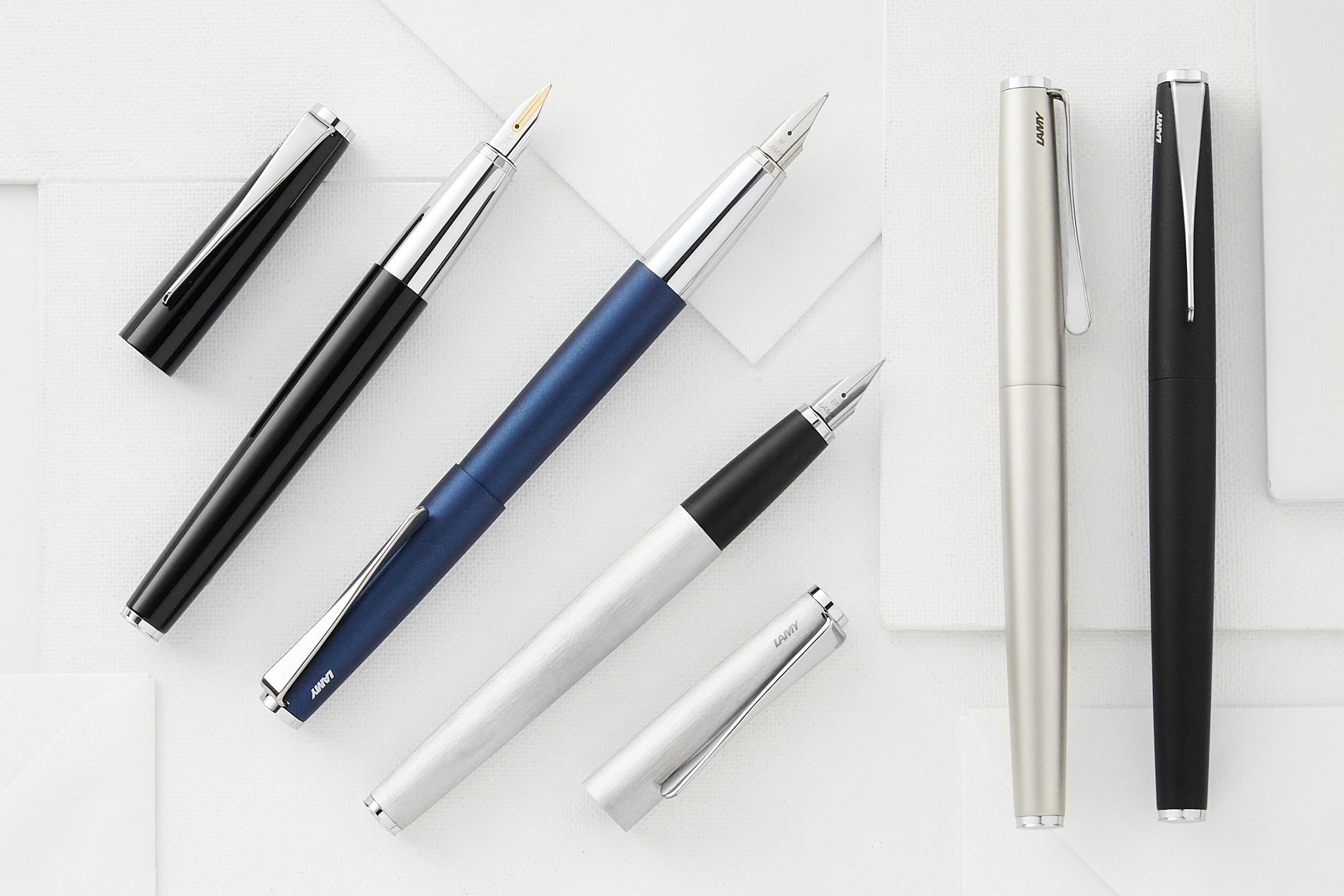 Five LAMY studio fountain pens on a light background