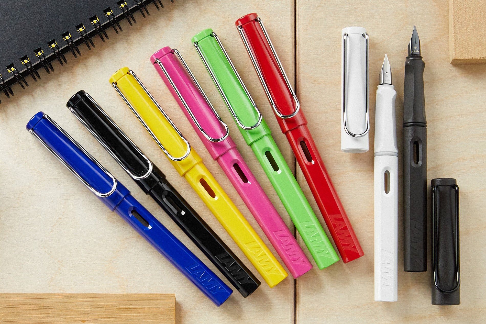 A fanned-out collection of colorful fountain pens