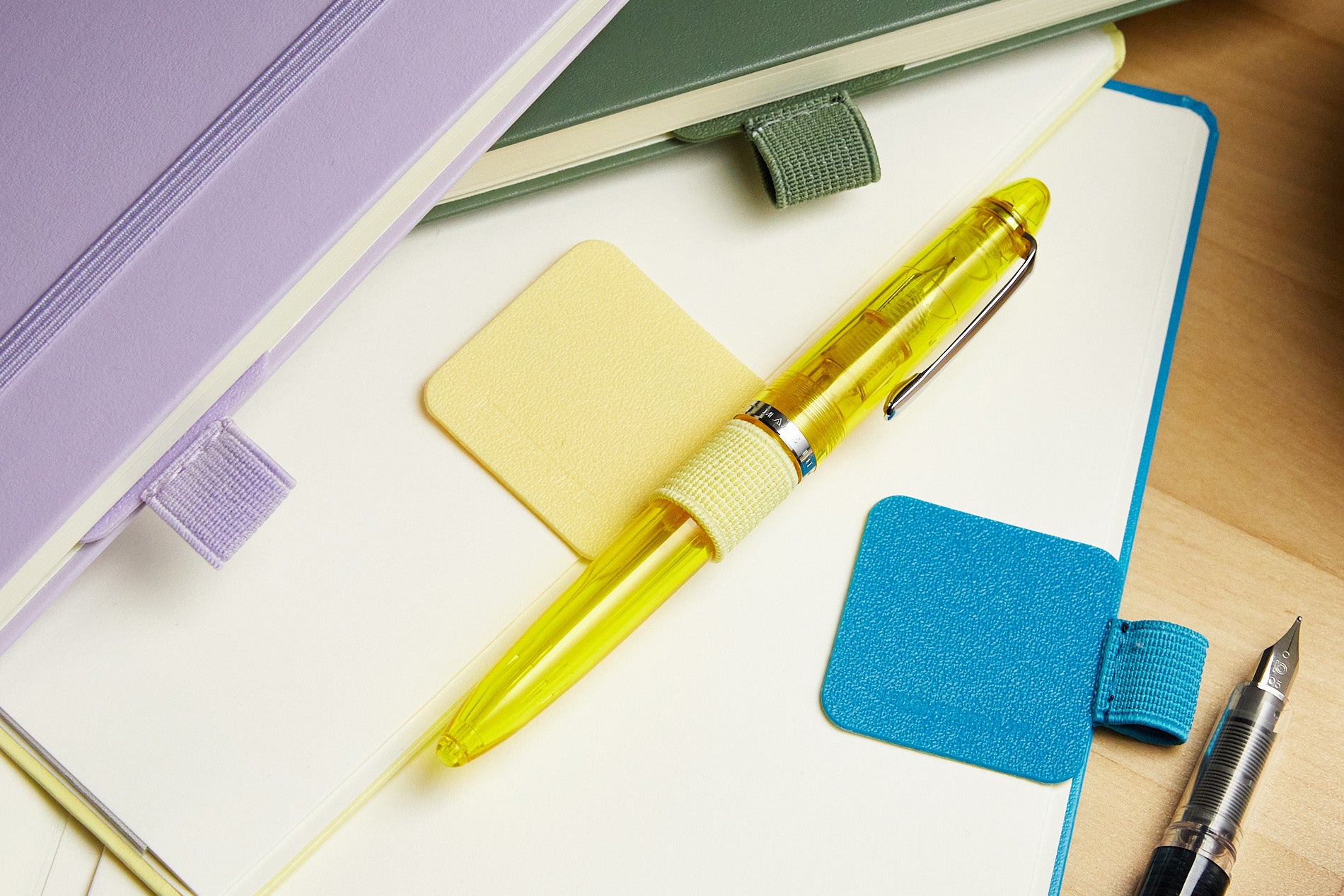 A variety of colored pen loops and pens attached to notebooks