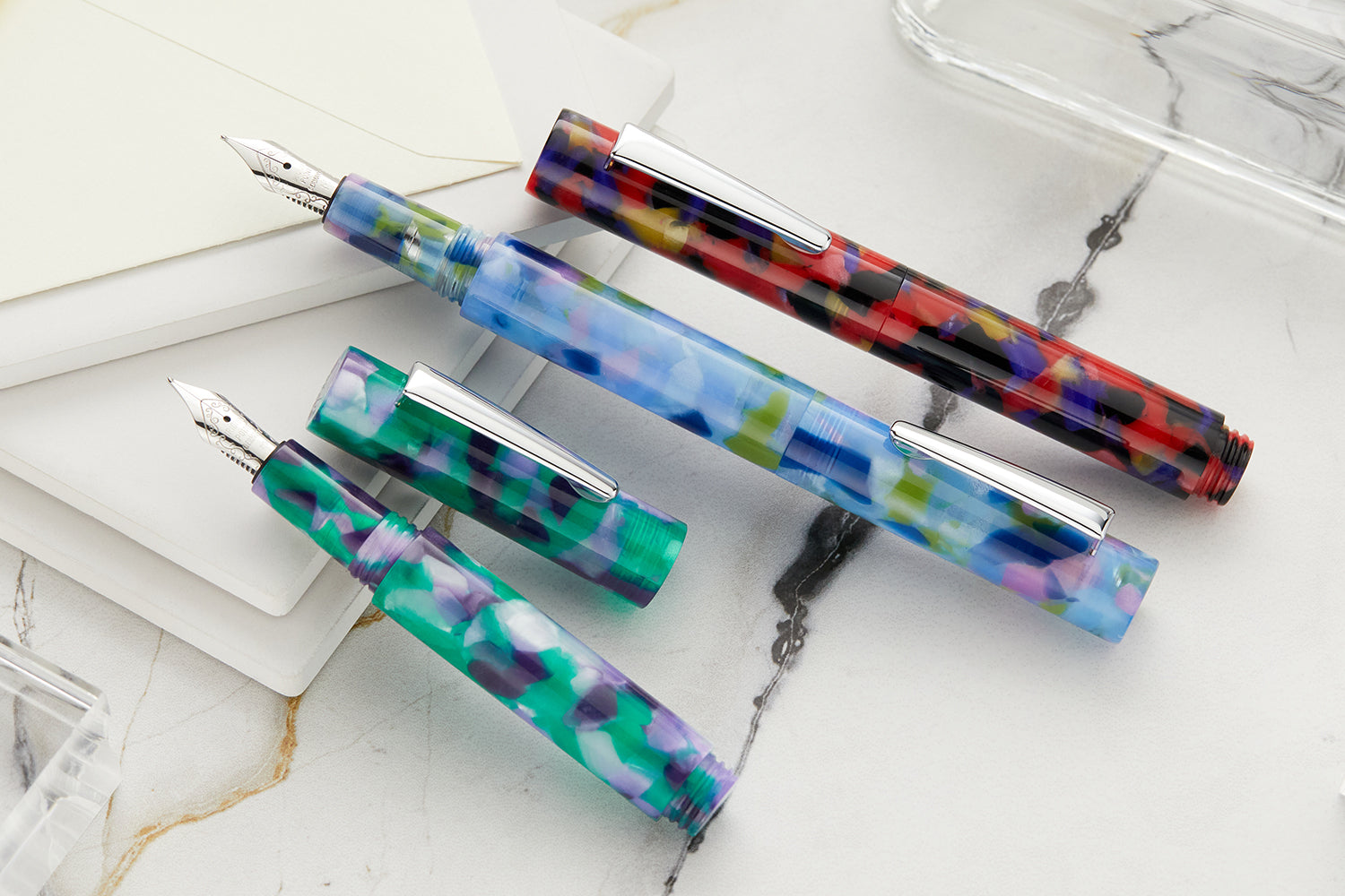 Monteverde MVP fountain pens, assorted colors on white notebook background