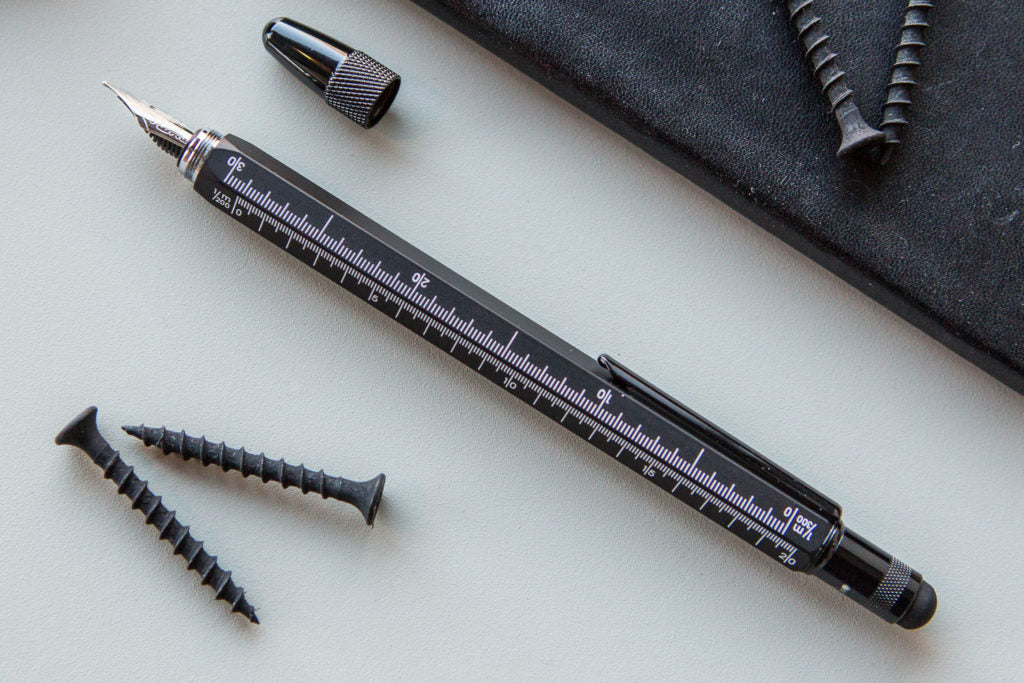 Monteverde Tool Pen in black with a white background and some screws