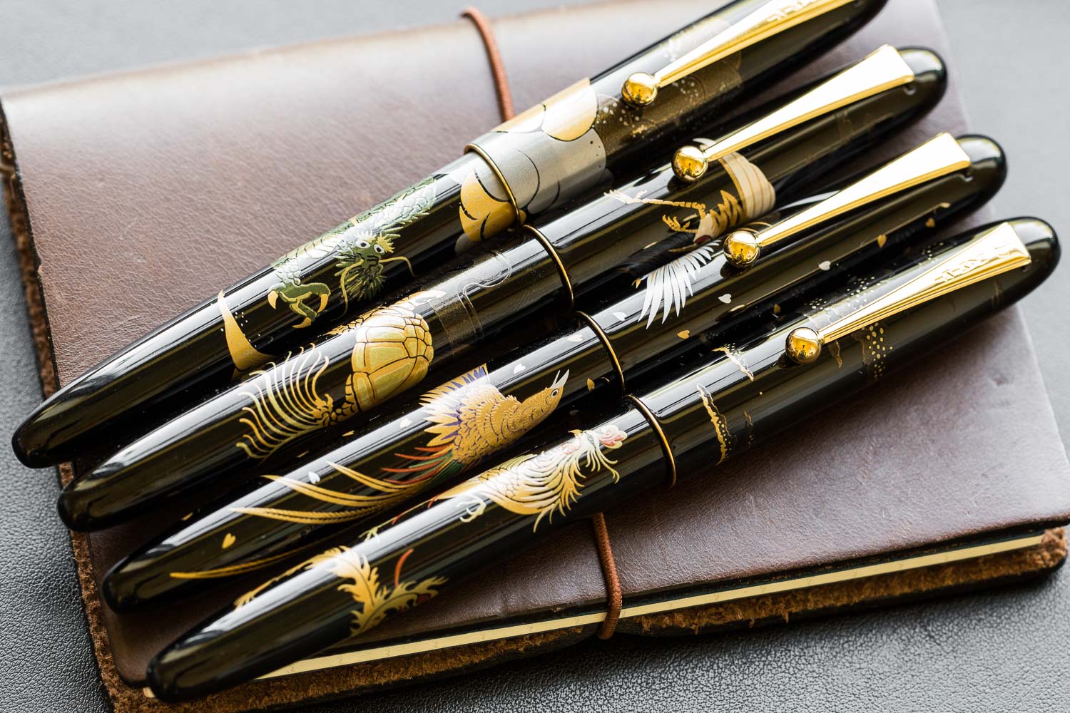 Assorted Nippon art fountain pens on leather journal