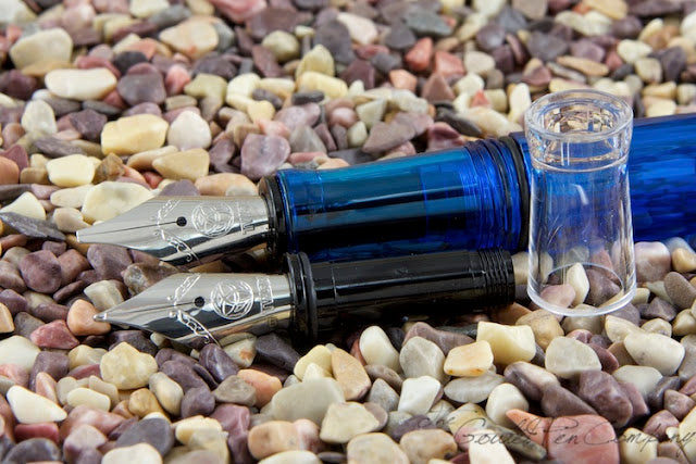 two TWSBI nibs up close on gravel background
