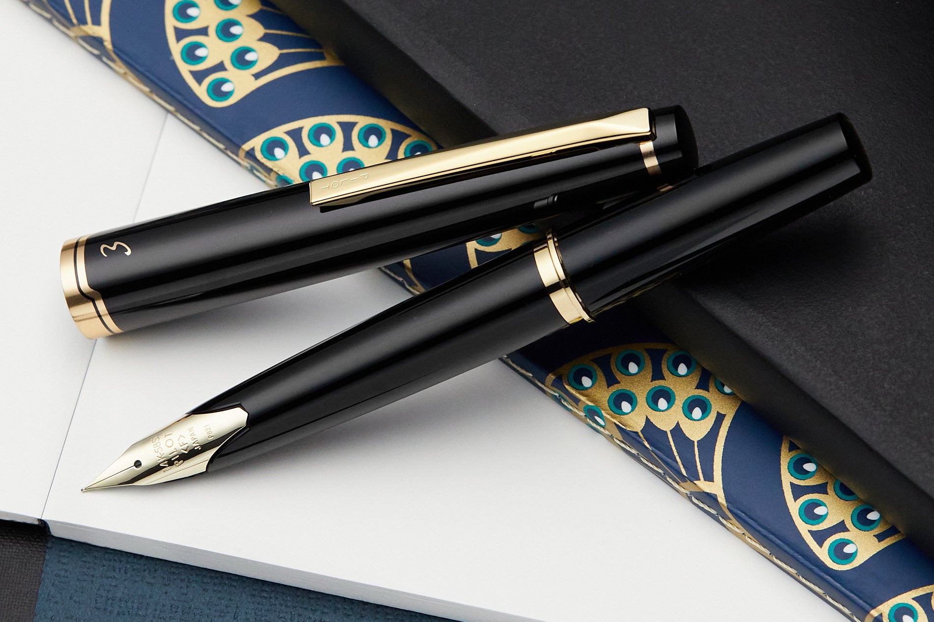 Pilot E95S fountain pen in black, open on a desk with notebooks