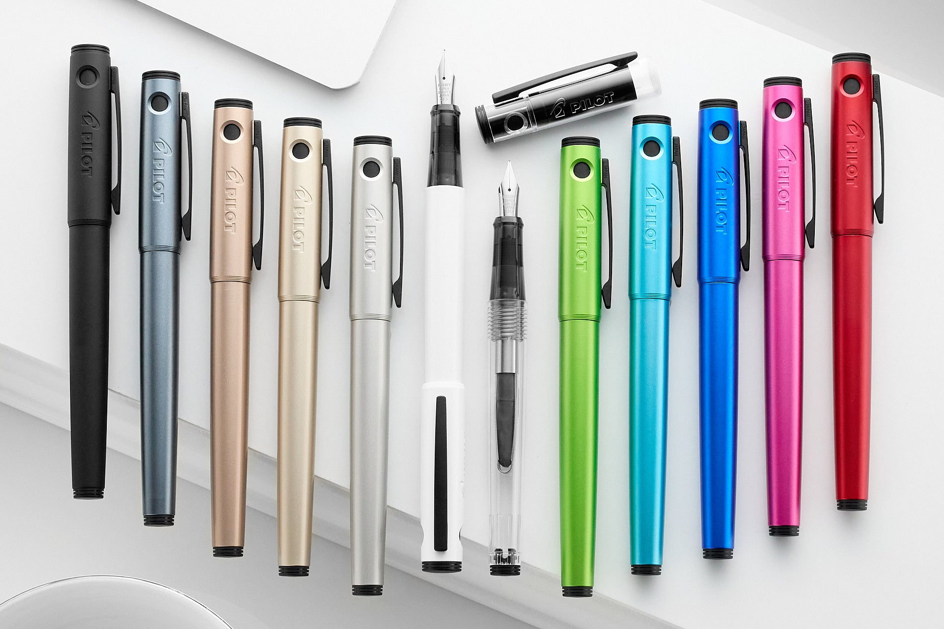 Assorted Pilot Explorer fountain pens in a wide variety of colors on a white background
