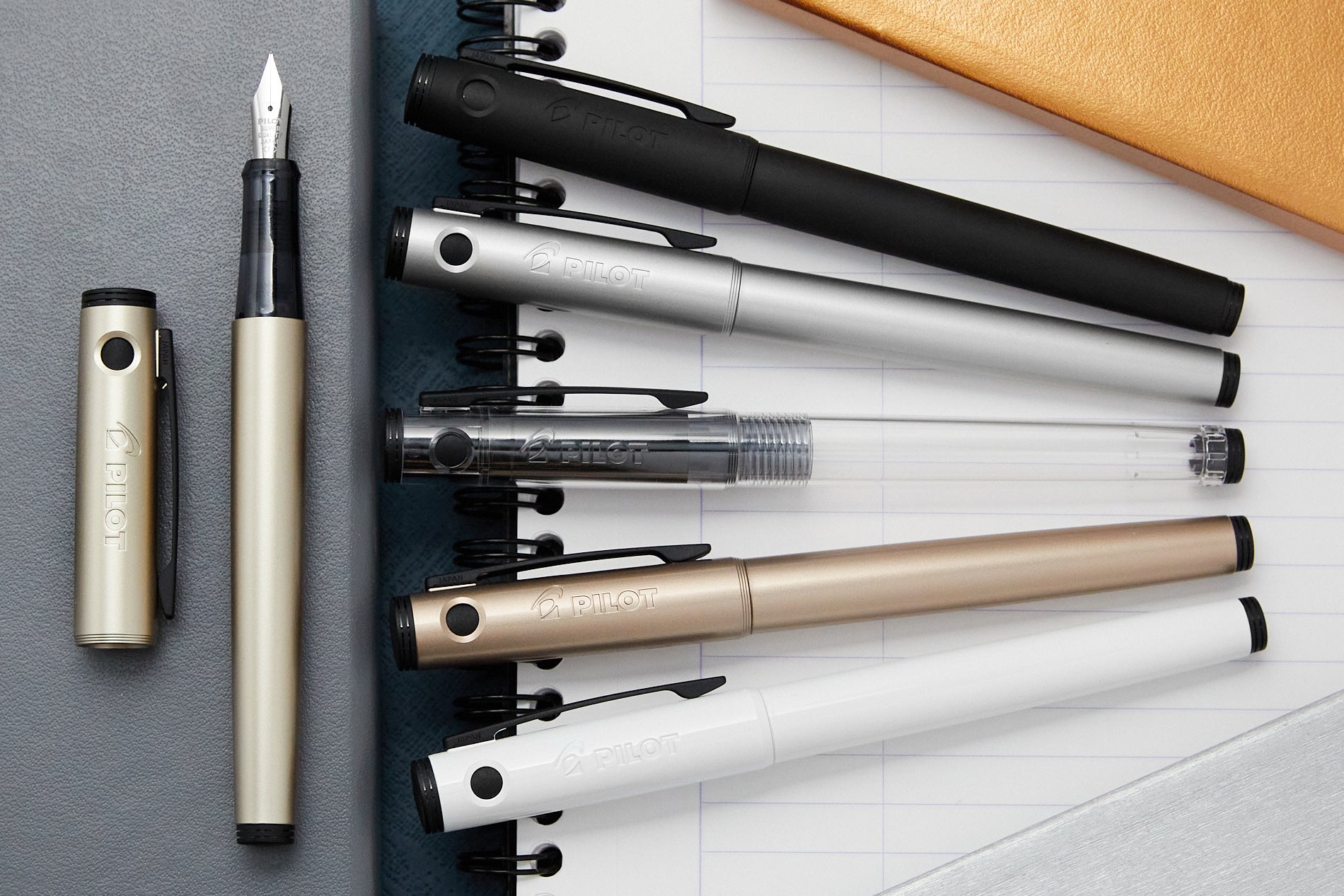Metallic looking fountain pens fanned out in a row