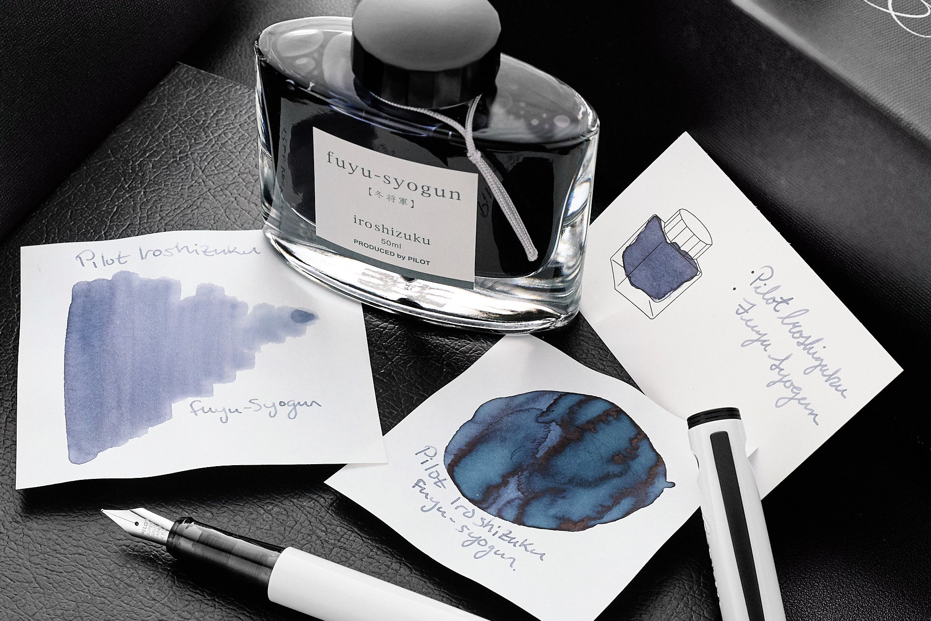 Pilot Iroshizuku Fuyu Syogun ink bottle with ink splatters on dark background