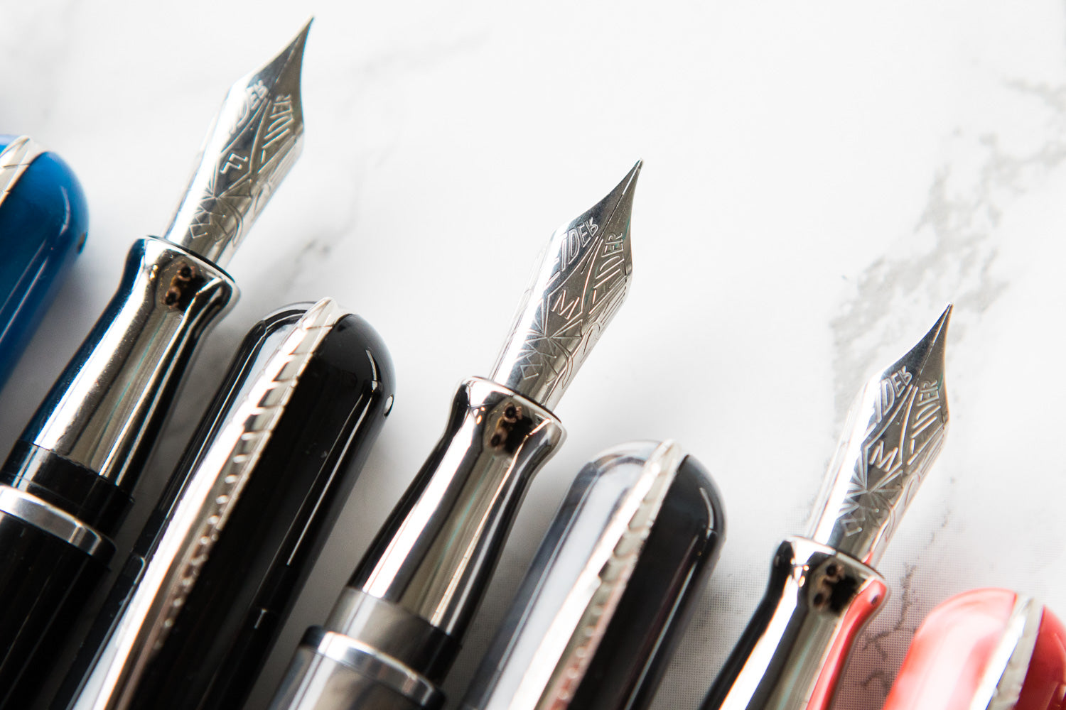 Up close photograph of Pineider Avatar fountain pen nibs and their caps