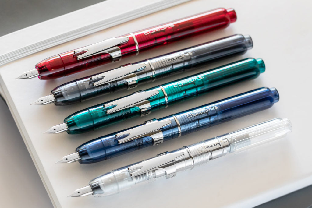 5 Platinum Curidas Retractable Fountain Pens sitting on a notepad