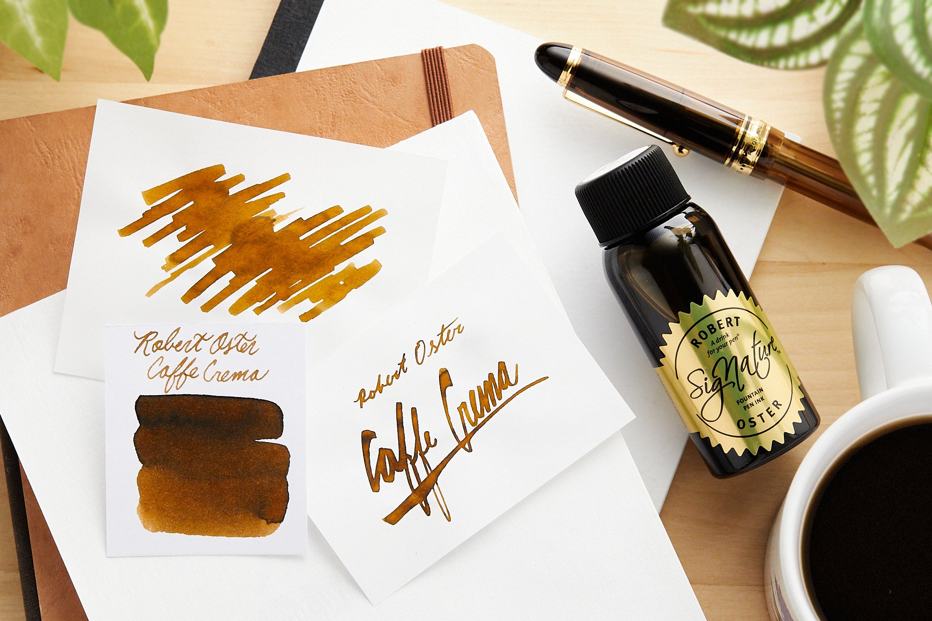 Robert Oster Caffe Crema Fountain Pen Ink bottle,  writing sample and swab on pale wood background