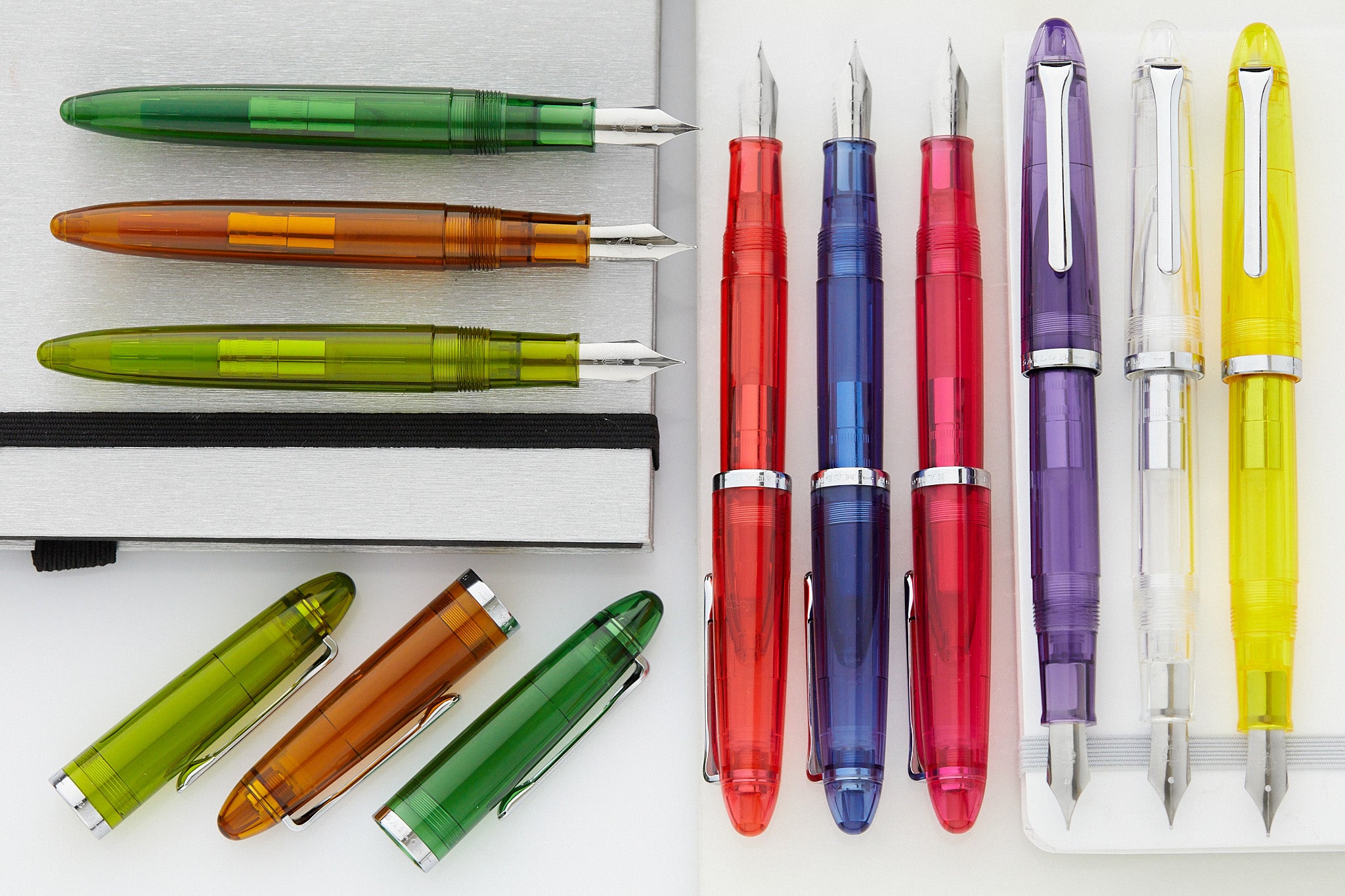 A rainbow of Sailor translucent fountain pens lined up neatly