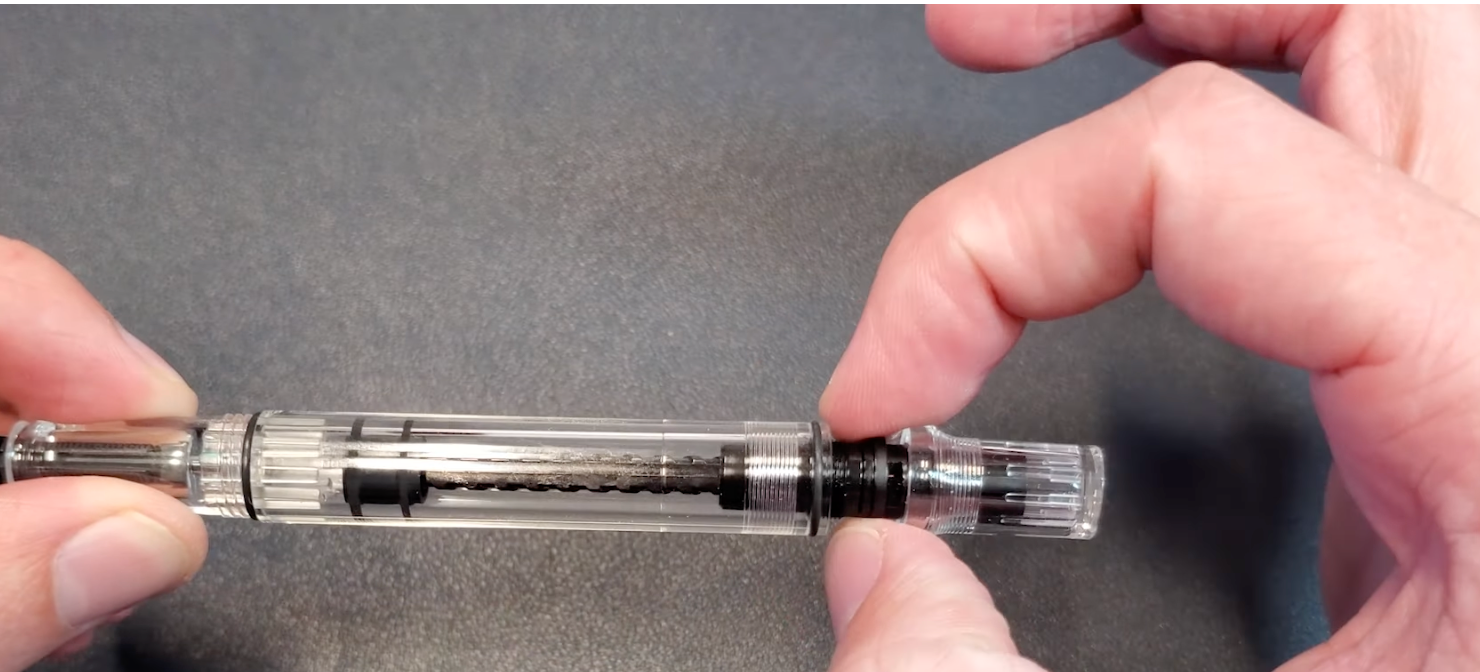 Fingers grabbing the TWSBI ECO piston unit on TWSBI ECO fountain pen