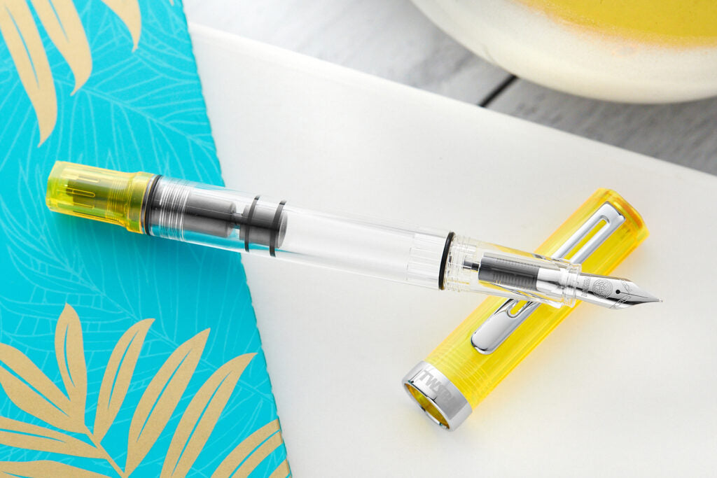 Transparent Yellow TWSBI ECO uncapped on white notebook unlined