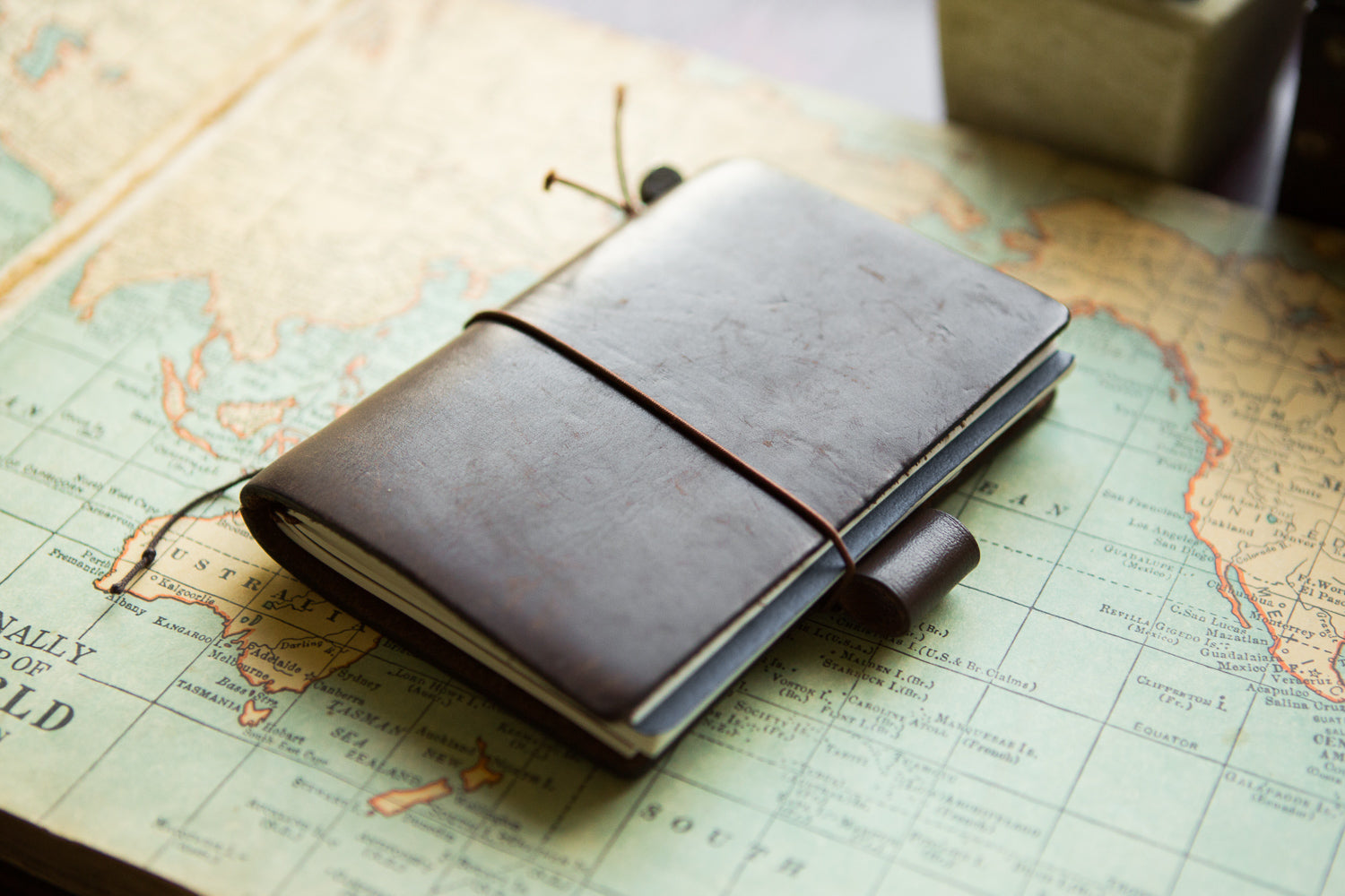 Brown Travelers Notebook on top of antique map