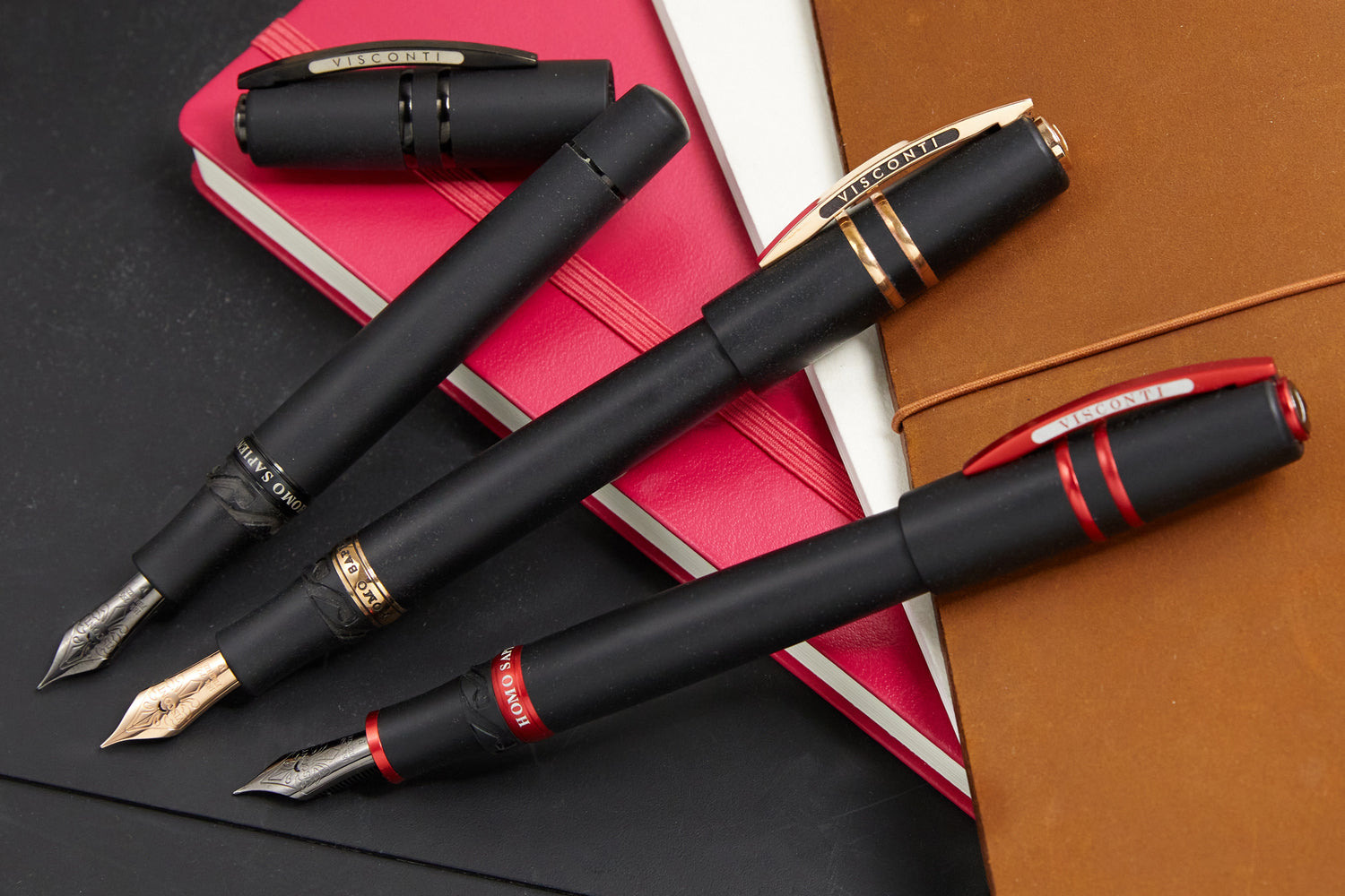 three black Visconti fountain pens with various trim colors