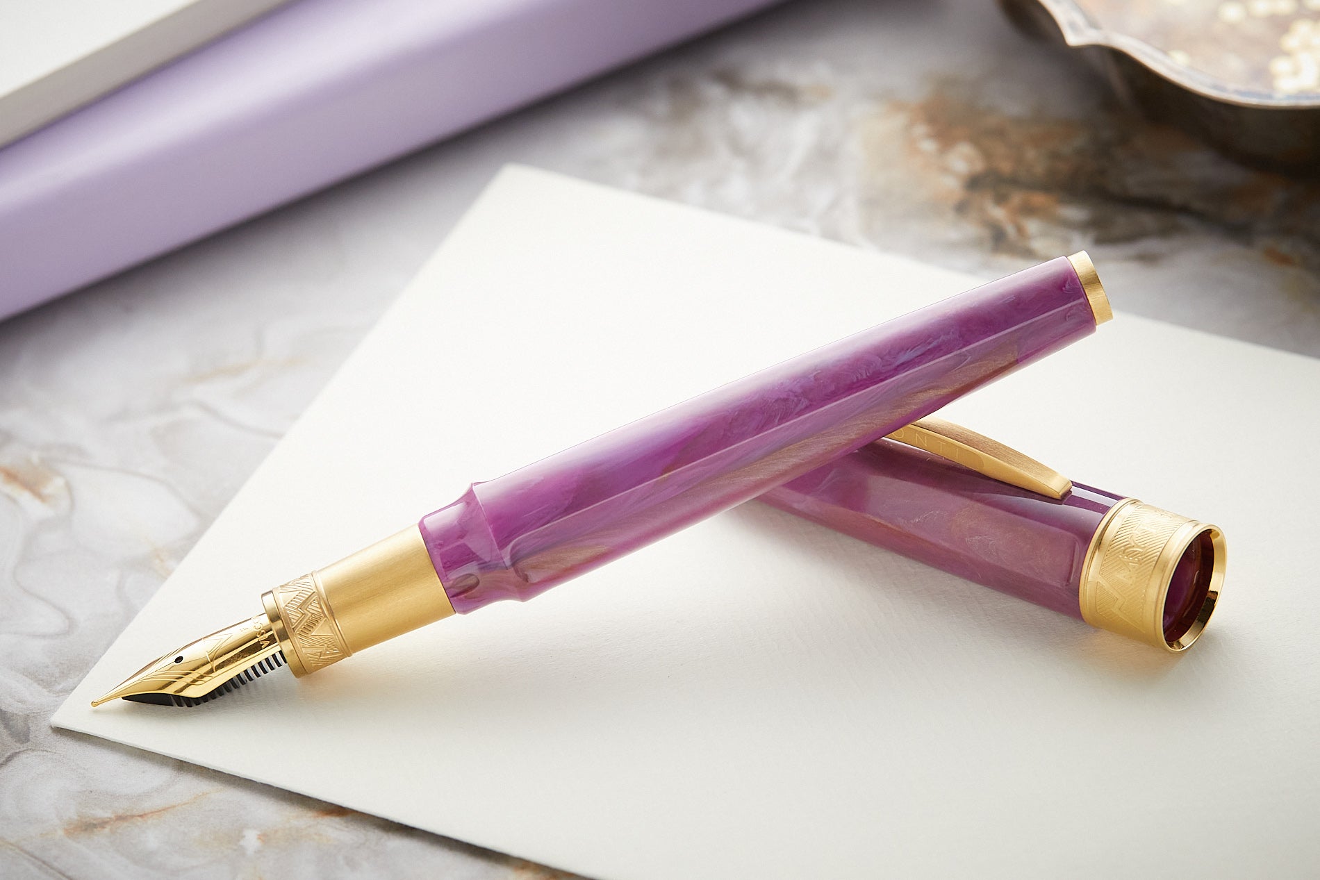 Visconti Mirage Mythos fountain in purple on white paper on top of a marble background