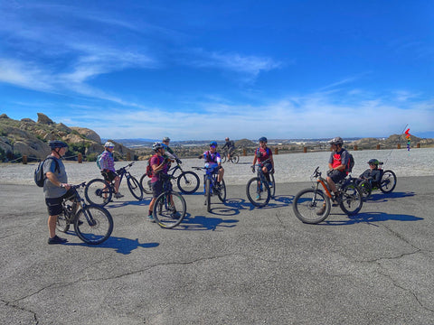 a group of cyclists ranging in age surrounded by rocks and vistas
