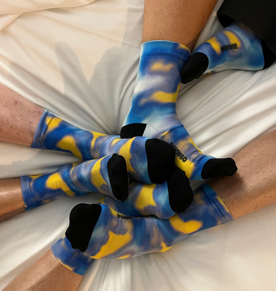 3 women wearing matching custom socks in blue and yellow tie dye