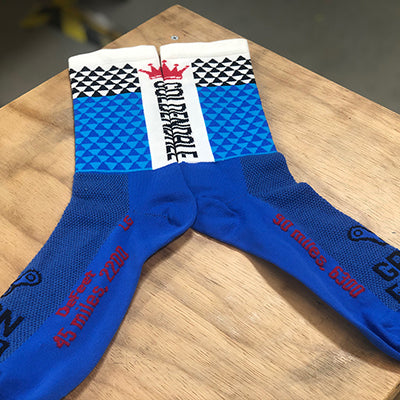 Custom DeFeet cycling socks in blue and white on a table