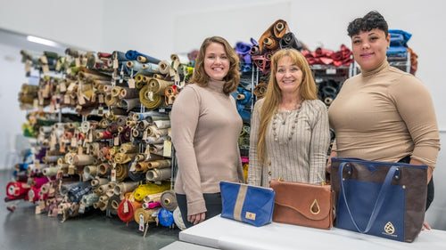 Three employees stand in front of our fabric rolls