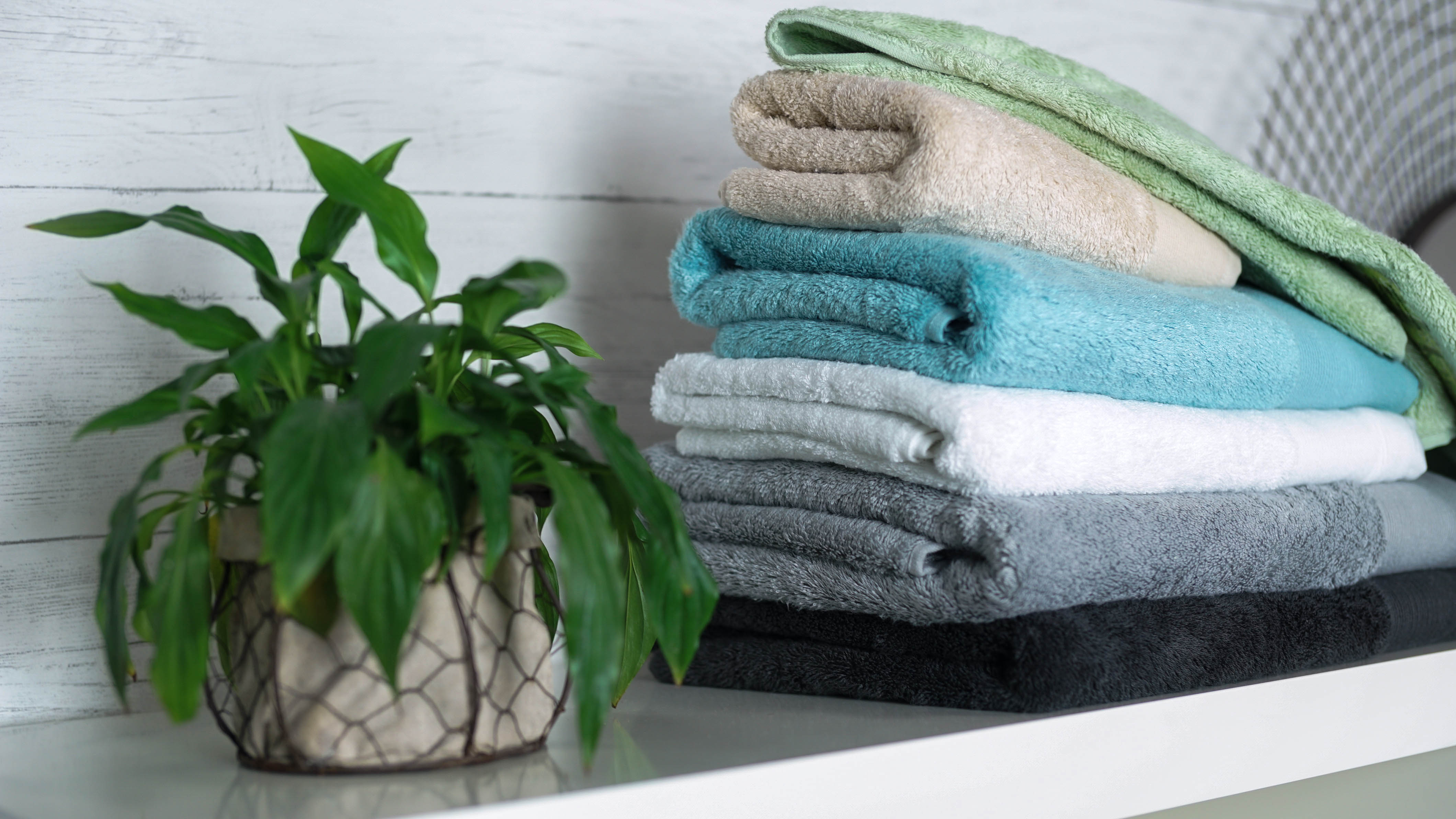 A stack of Bamboo Towels next to a potted plant