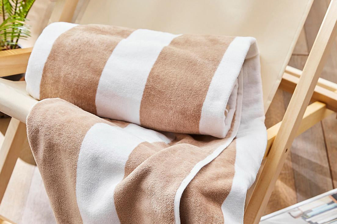 Cabana Stripe Beach Towel Taupe Rolled Up on Deck Chair