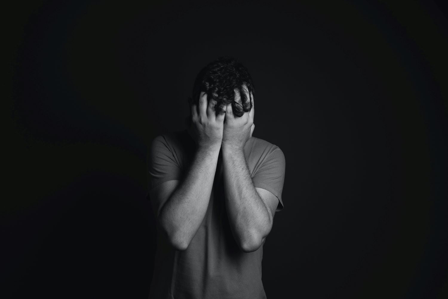 Gray scale Photo of Man Covering Face With His Hands