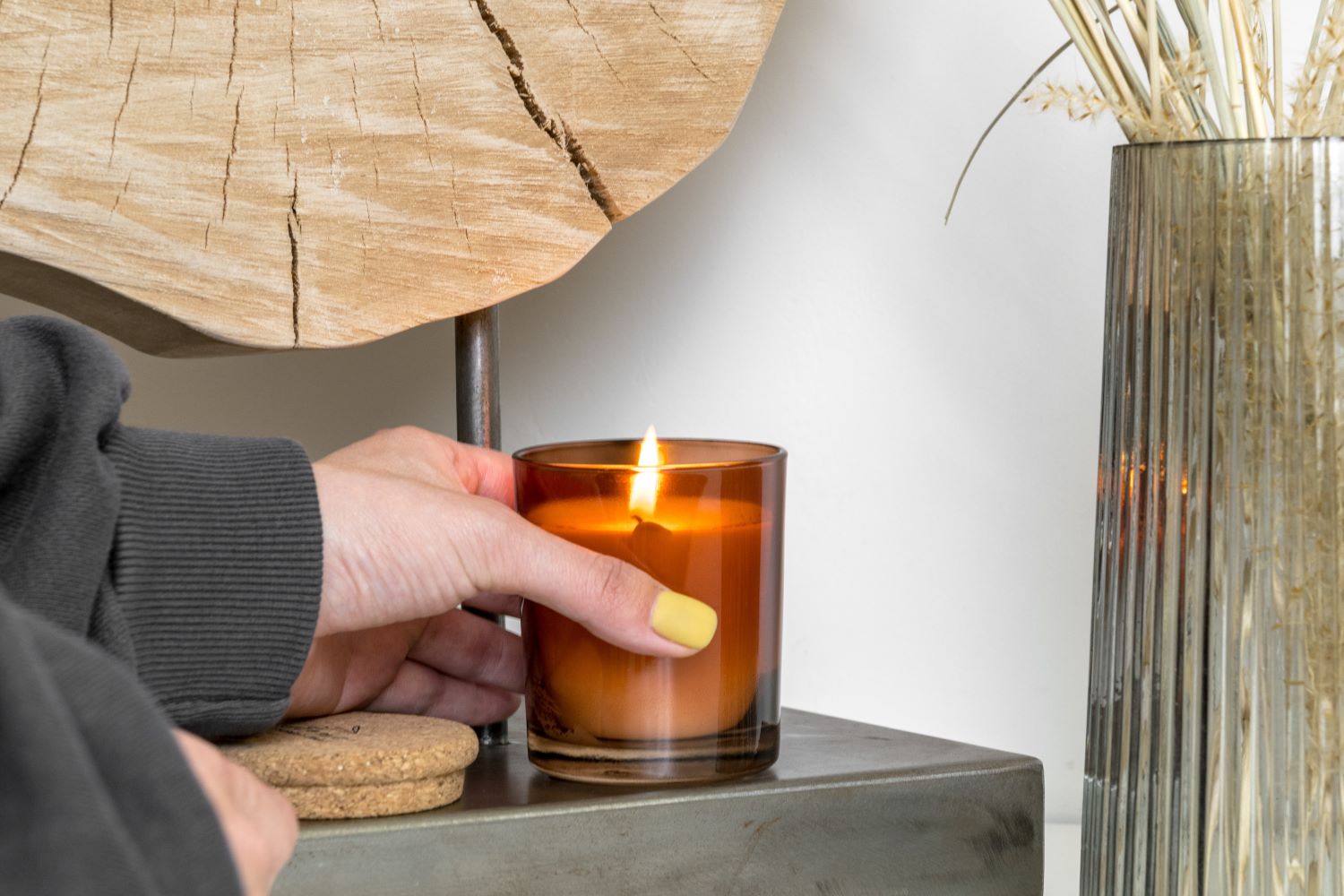 Person Holding Brown Glass with Burning Candle