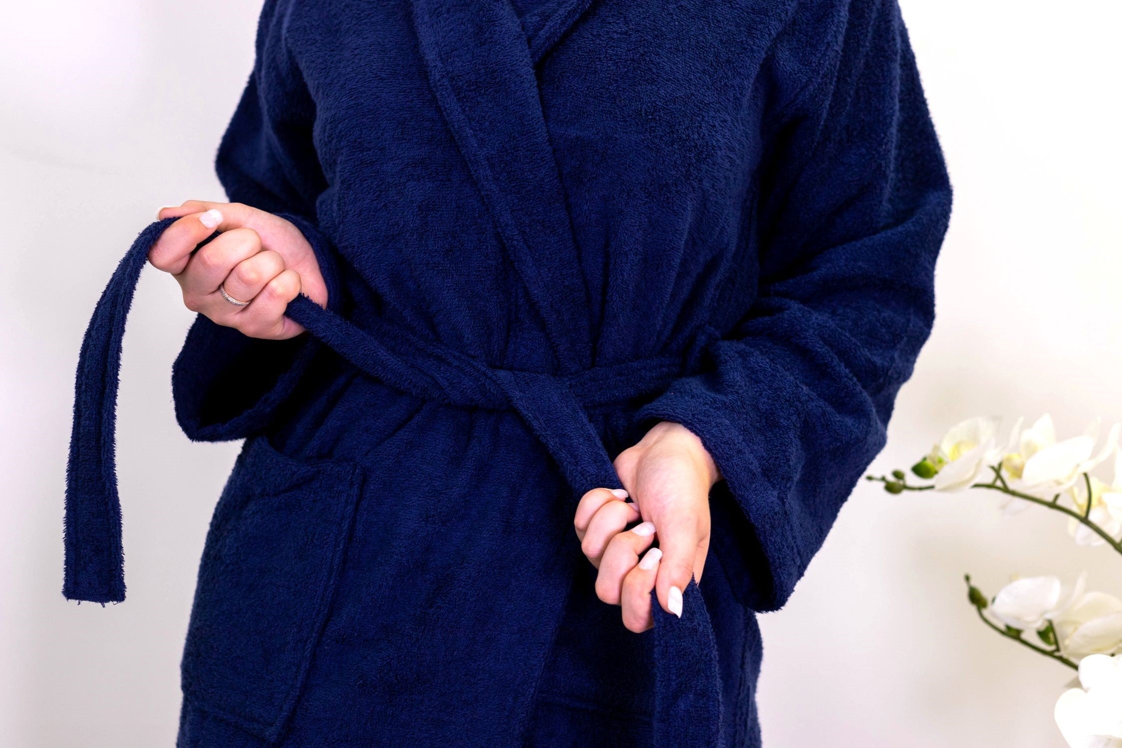 A Woman Tying Up a Navy Bathrobe