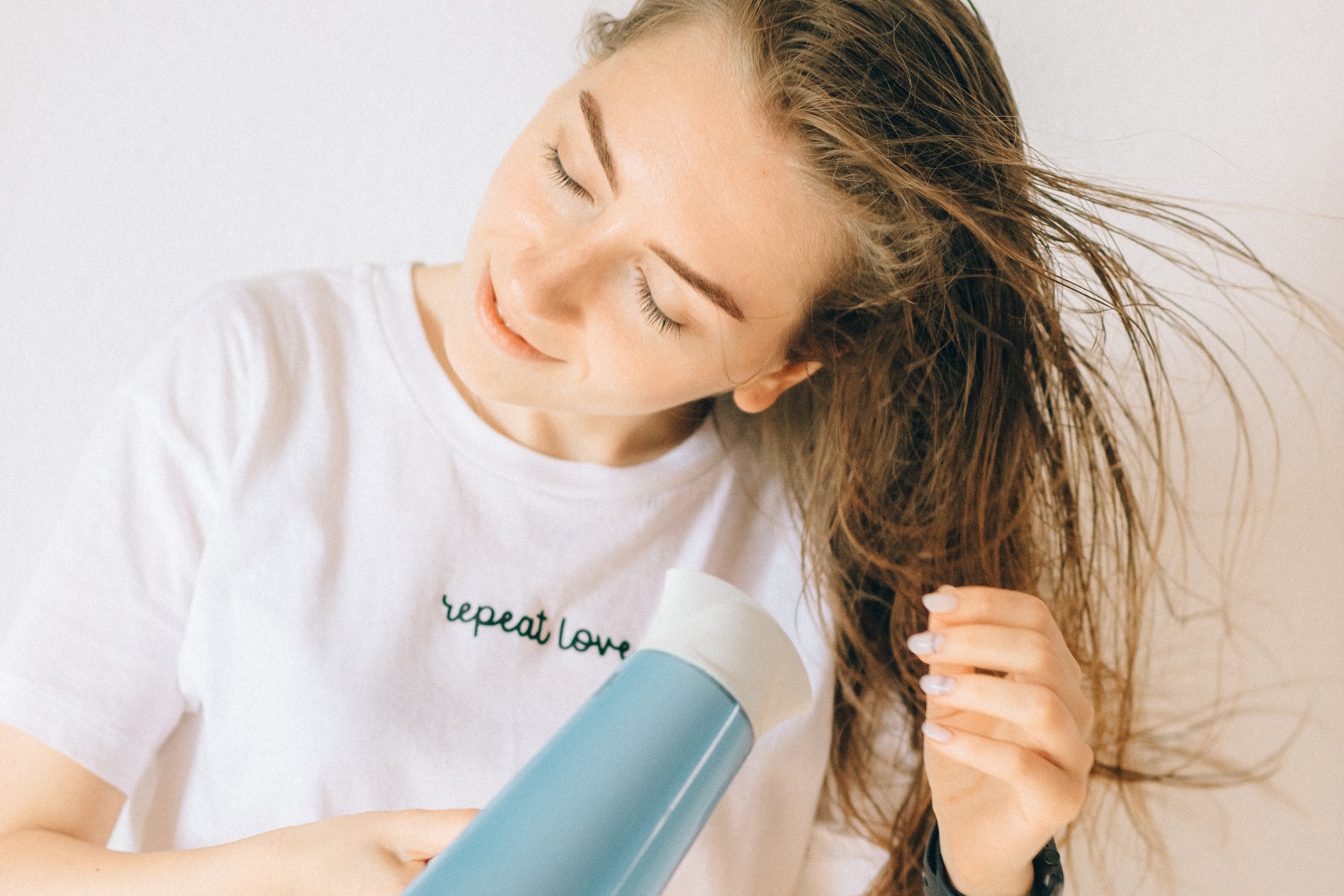 Woman in White Shirt Drying Her Hair