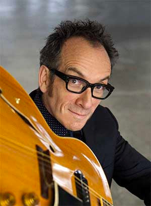 Elvis Costello Wearing Glasses with Guitar