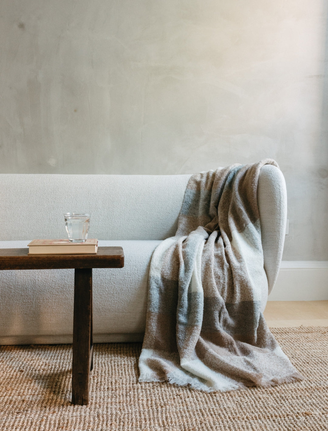 Camel and grey patterned alpaca blanket on a white sofa