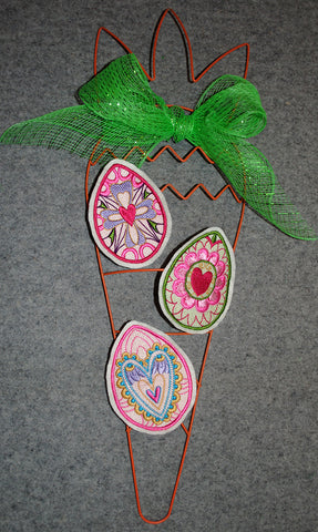 Picture of 3 machine embroidered Easter eggs glued to carrot metal frame at Sew Inspired by Bonnie