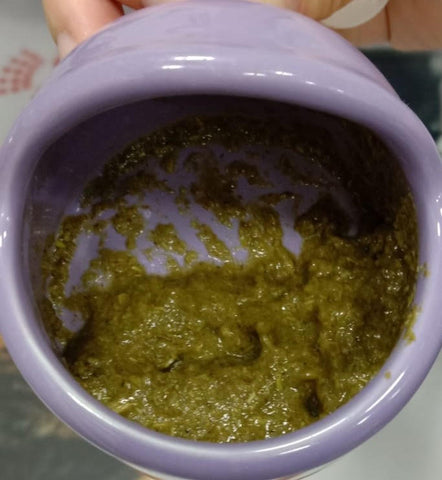 Mashed rabbit food that looks like green vomit in a cute, purple bowl