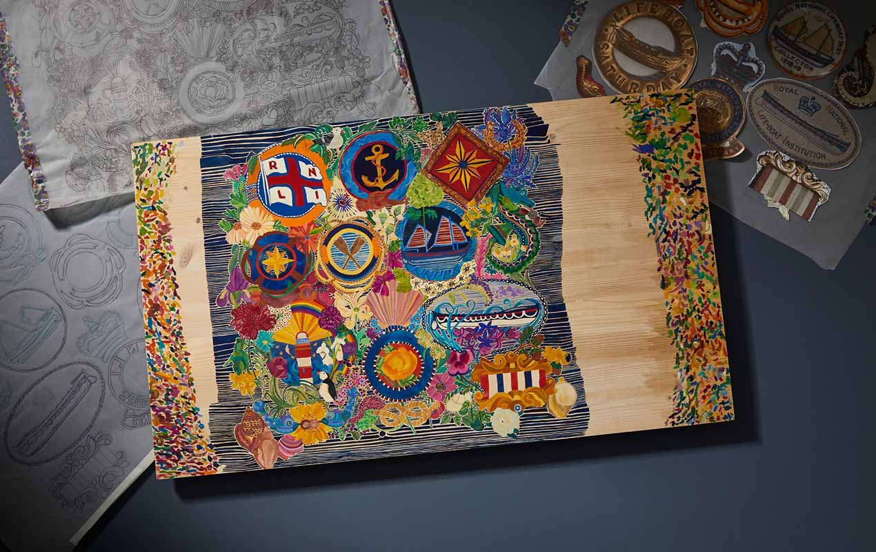 A wooden board that has been painted with colourful RNLI icons.