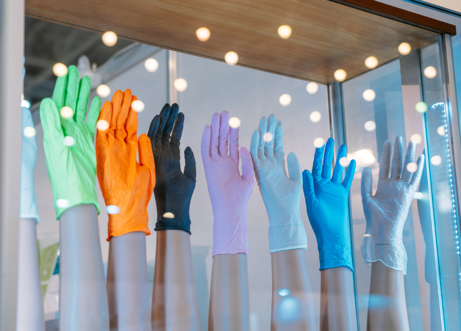 8 mannequin hands in a window. each hand is wearing a different color of disposable glove