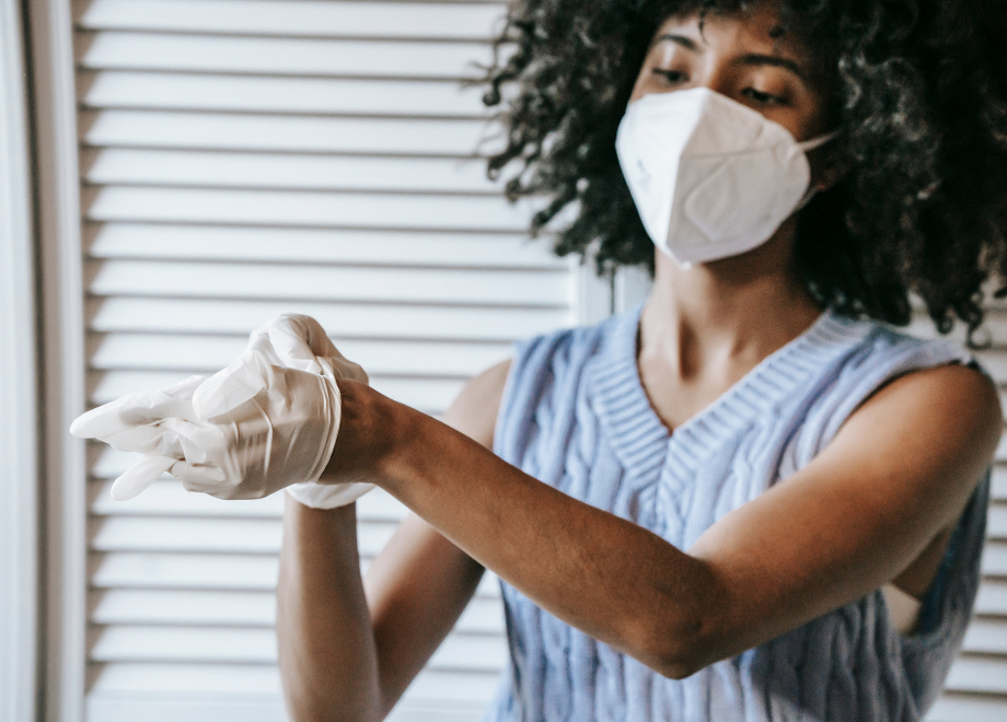 a woman is doffing a disposable glove from her left hand