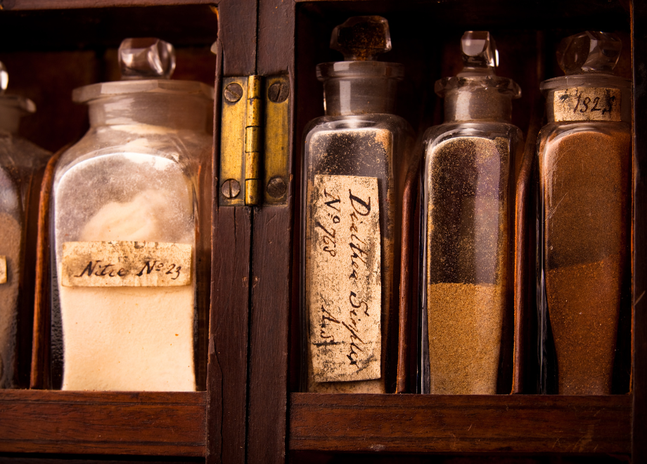 a row of vintage medicine bottles on a shelf