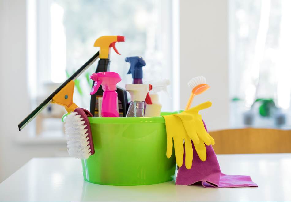 Bucket of cleaning supplies on a table