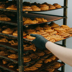 person wearing black nitrile gloves and working in a bakery