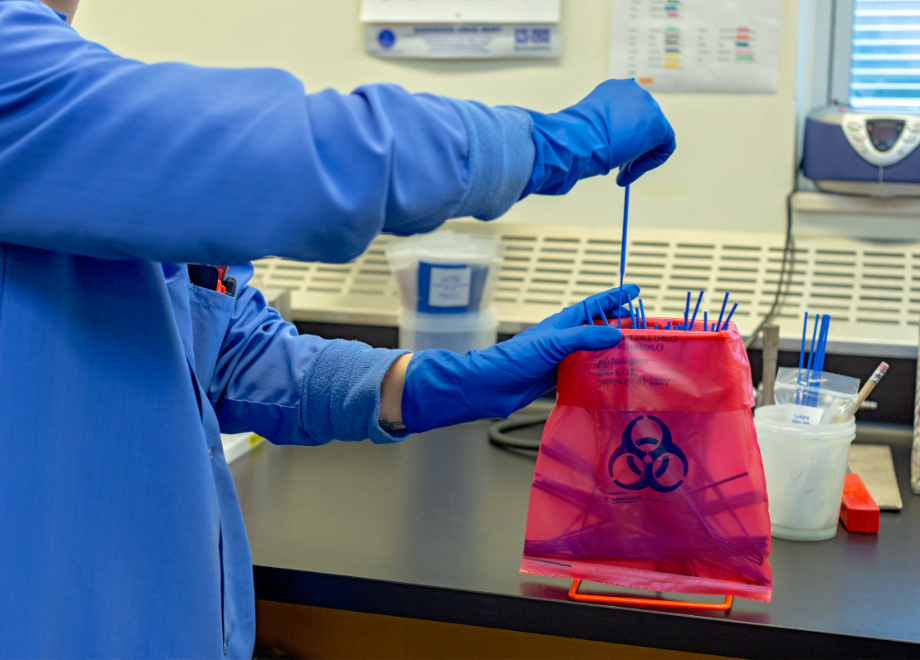 person wearing blue response er disposable gloves in a lab