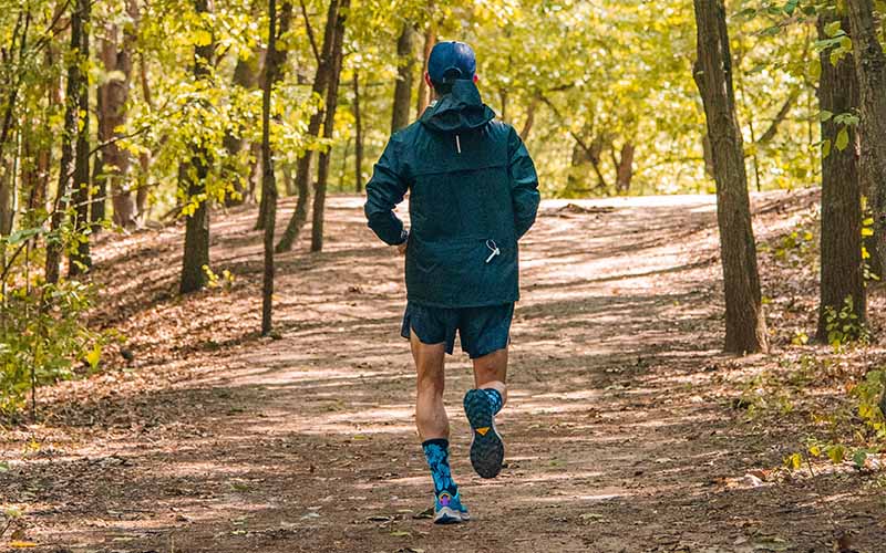 Man running on a trail in a trail running shoe