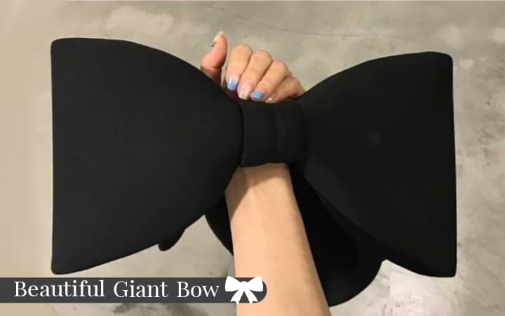 Beautiful oversized bow on display on the black Belle Bow Bag, being carried on the wrist