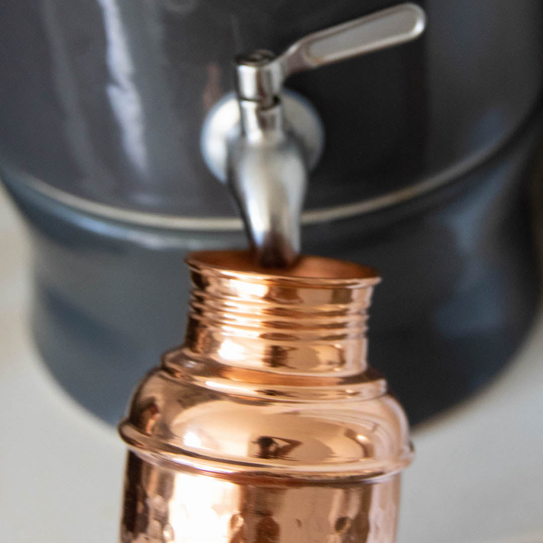 Copper bottle being filled with water