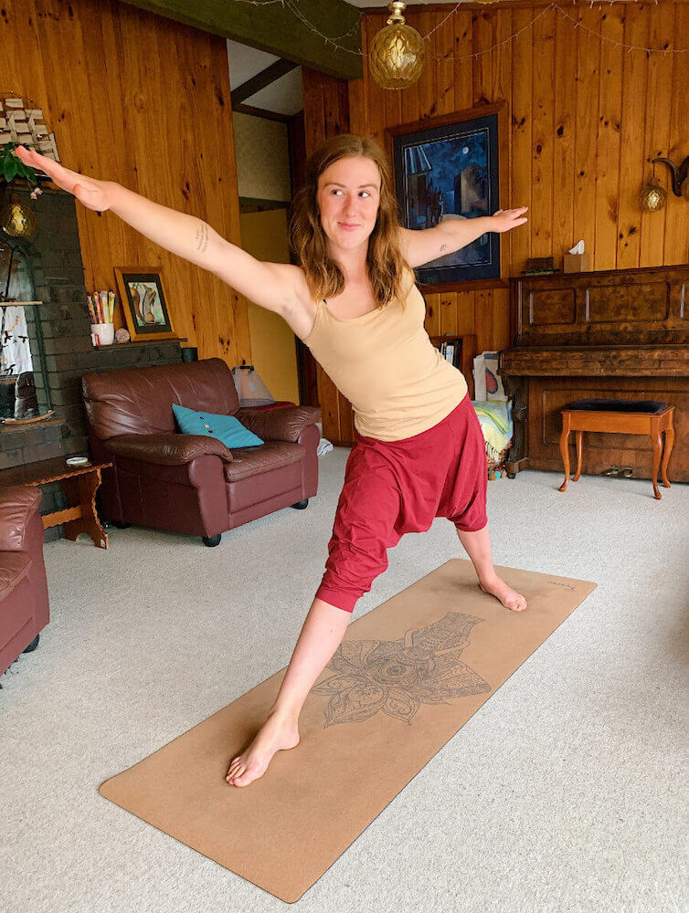Ethically Kate striking a warrior pose on a cork yoga mat
