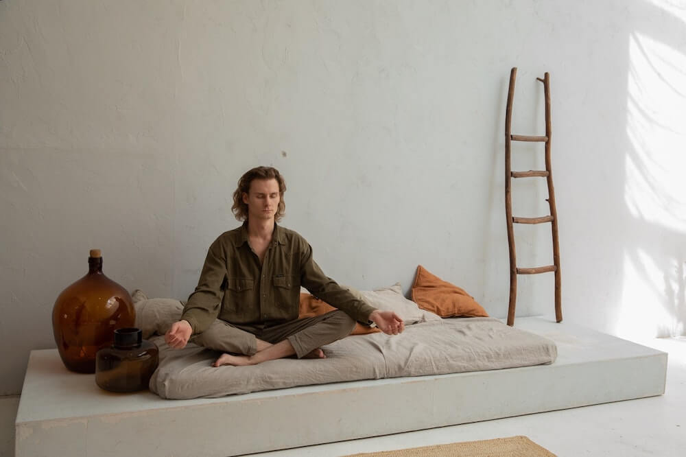 Man meditating on bed