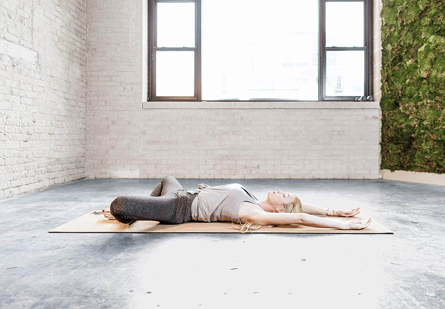 Yogini in savasana on cork yoga mat
