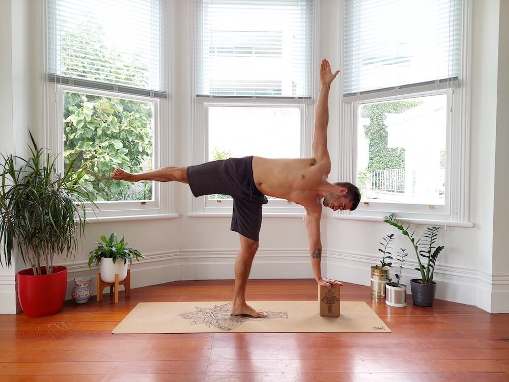 Jaroslav performing the half moon pose with yoga block