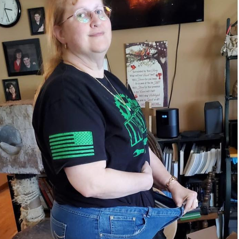 Woman in a black t-shirt standing in a living room.